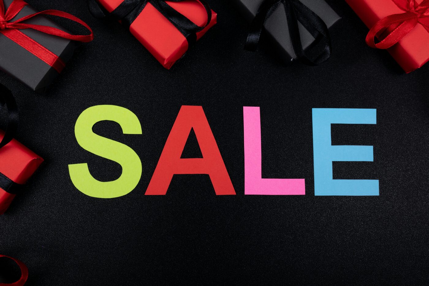 Vibrant SALE text surrounded by gift boxes offers perfect promotional imagery.